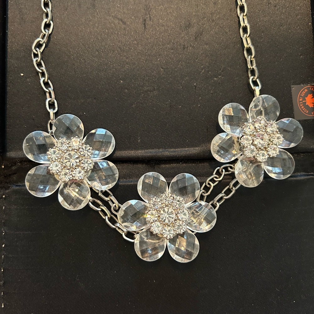 Silver colored chain with 3 Flowers . Flowers are clear with rhinestone center.